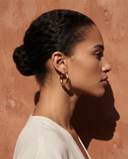 Pieza 1: mujer de perfil con los aros dorados, al sol